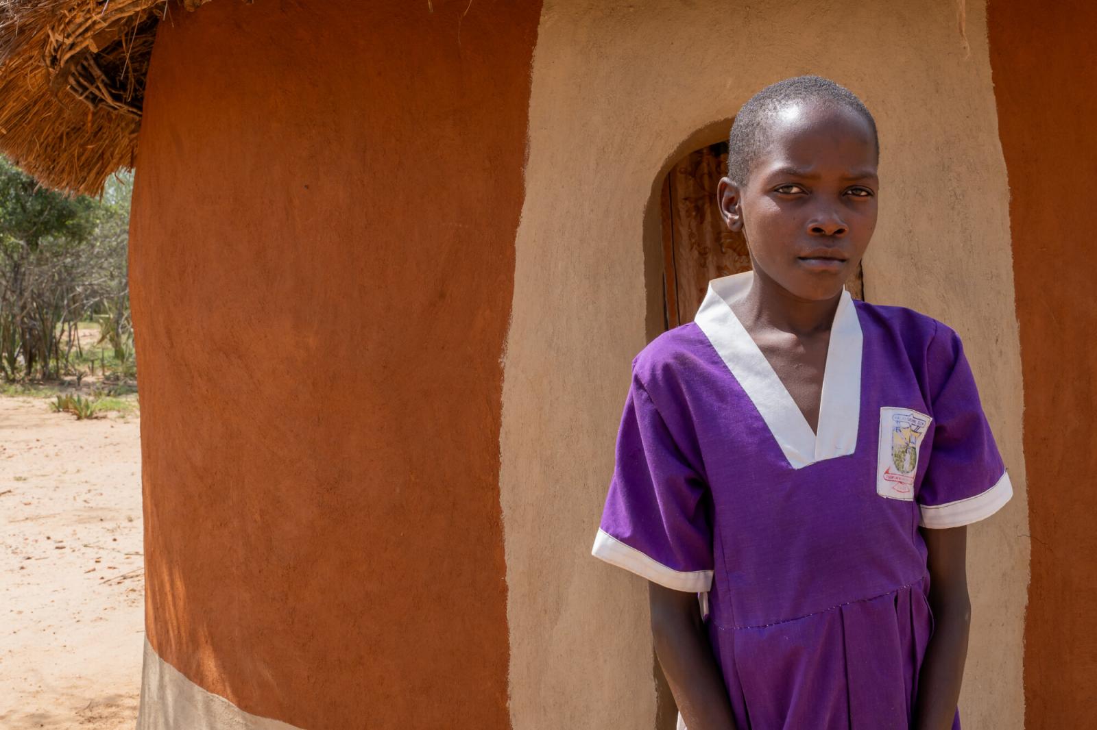 Nakiru stands outside her family's home