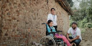 Volunteers with girl in wheelchair