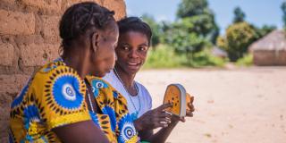 Volunteer using a talking book to teach about sexual and reproductive health.
