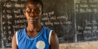 Juliet stands in an empty classroom.
