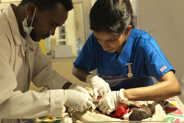 Doctors attend to an infant in Ethiopia