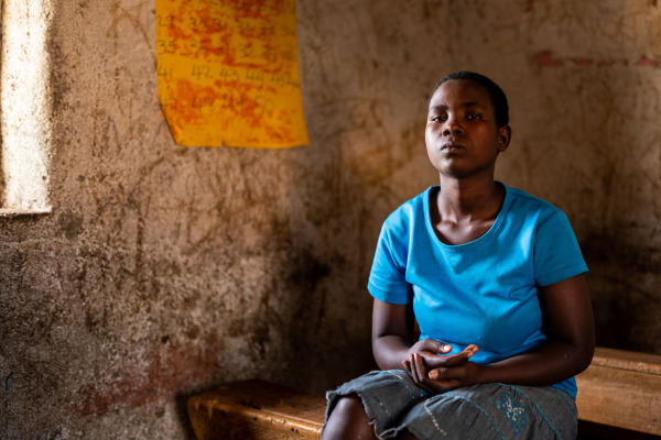 Girl in blue t-shirt sitting in an empty classroom