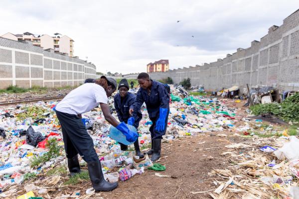 Lawrence showing Vanessa and Pauline how to segregate waste.