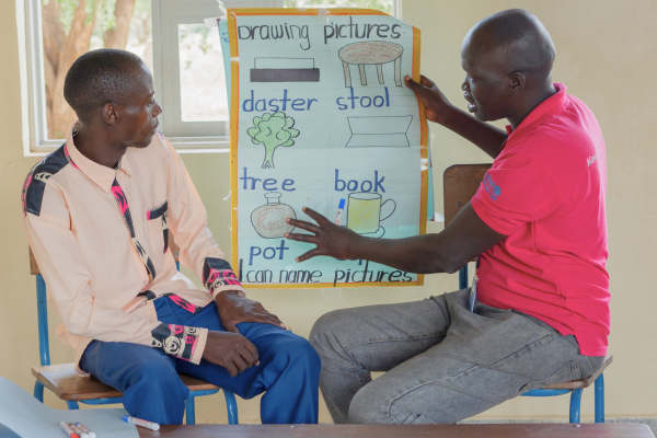 VSO volunteer Alfred sits with Elijah