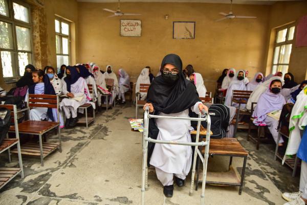 Sana in her classroom with her walking frame