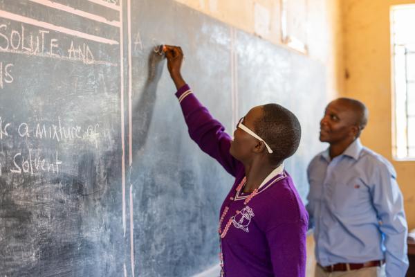 Alice works at the chaulkboard in her classroom