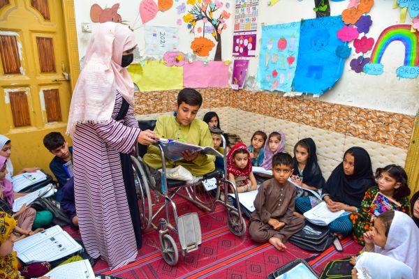 Khadija helping Sohail with his work.
