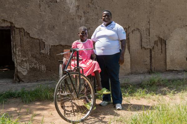 Volunteer Semmy and Nangiro stand outside a classroom together